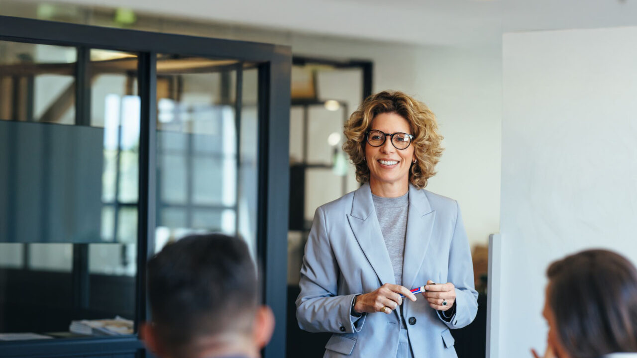 Mature business woman having a discussion with her team. Woman leading a meeting in an office